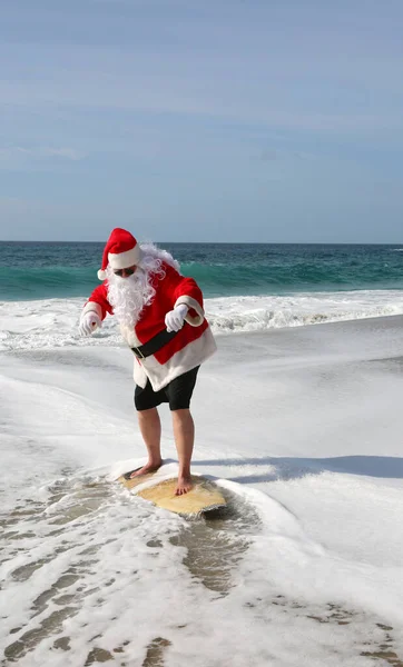 给圣诞老人冲浪 圣诞节 圣诞节假期 冲浪圣诞老人 冲浪板 挂十号圣诞老人在度假时乘风破浪 圣诞前夕前的圣诞老人 圣诞老人和冲浪板 圣诞老人在他的冲浪板上冲浪 浪涌上来 — 图库照片