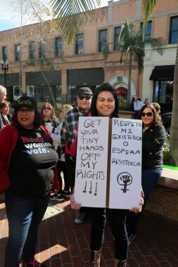 SANTA ANA, CALIFORNIA - JANUARY 21, 2017: People from Orange County carry signs, and wear t-shirts with slogans marched in Santa Ana today for the Orange County Women's March. Editorial. Pink Pussy Hat Protest March. pink pussy hats. 