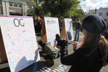 SANTA ANA, CALIFORNIA - JANUARY 21, 2017: People from Orange County carry signs, and wear t-shirts with slogans marched in Santa Ana today for the Orange County Women's March. Editorial. Pink Pussy Hat Protest March. pink pussy hats. 