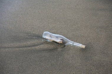 Şişedeki mesaj. Yıllarca okyanusta özgürce yüzdükten sonra şişedeki mesaj kıyıya vurur. Bir cam şişenin içindeki mesaj kumsala vurmuş. Yardım. Hazine haritası. Korsan Mesajı. Bir not yazdım. Yardım talep ediyorum. Issız Ada.
