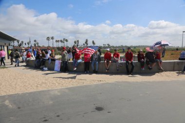 Huntington Sahili, CA - 25 Mart 2017: Amerika 'yı Tekrar Harika Yap Yürüyüşü. Cumhuriyetçi başkan Donald Trump 'ın destekçileri ve protestocuları, Huntington Beach' teki bir MAGA yürüyüşünde bayraklar sallayıp, pankart sallıyorlar. Gururlu Amerikalılar Trump 'ı destekliyor. Başkan Trump.