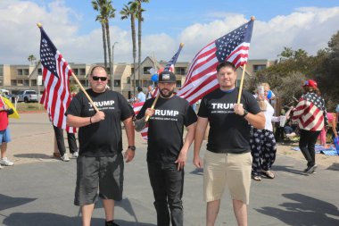 Huntington Sahili, CA - 25 Mart 2017: Amerika 'yı Tekrar Harika Yap Yürüyüşü. Cumhuriyetçi başkan Donald Trump 'ın destekçileri ve protestocuları, Huntington Beach' teki bir MAGA yürüyüşünde bayraklar sallayıp, pankart sallıyorlar. Gururlu Amerikalılar Trump 'ı destekliyor. Başkan Trump.