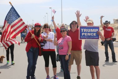 Huntington Sahili, CA - 25 Mart 2017: Amerika 'yı Tekrar Harika Yap Yürüyüşü. Cumhuriyetçi başkan Donald Trump 'ın destekçileri ve protestocuları, Huntington Beach' teki bir MAGA yürüyüşünde bayraklar sallayıp, pankart sallıyorlar. Gururlu Amerikalılar Trump 'ı destekliyor. Başkan Trump.