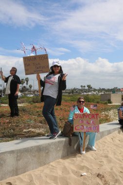 Huntington Sahili, CA - 25 Mart 2017: Amerika 'yı Tekrar Harika Yap Yürüyüşü. Cumhuriyetçi başkan Donald Trump 'ın destekçileri ve protestocuları, Huntington Beach' teki bir MAGA yürüyüşünde bayraklar sallayıp, pankart sallıyorlar. Gururlu Amerikalılar Trump 'ı destekliyor. Başkan Trump.