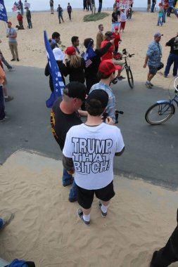 Huntington Sahili, CA - 25 Mart 2017: Amerika 'yı Tekrar Harika Yap Yürüyüşü. Cumhuriyetçi başkan Donald Trump 'ın destekçileri ve protestocuları, Huntington Beach' teki bir MAGA yürüyüşünde bayraklar sallayıp, pankart sallıyorlar. Gururlu Amerikalılar Trump 'ı destekliyor. Başkan Trump.