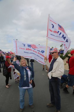 Başkan Donald Trump. Huntington Sahili, CA - 25 Mart 2017: Amerika 'yı Tekrar Harika Yap Yürüyüşü. Cumhuriyetçi başkan Donald Trump 'ın destekçileri ve protestocuları Huntington Beach' teki MAGA yürüyüşünde tezahürat ve alay ediyorlar. Başkan Trump Destekçileri. 