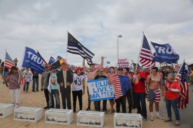 Başkan Donald Trump. Huntington Sahili, CA - 25 Mart 2017: Amerika 'yı Tekrar Harika Yap Yürüyüşü. Cumhuriyetçi başkan Donald Trump 'ın destekçileri ve protestocuları Huntington Beach' teki MAGA yürüyüşünde tezahürat ve alay ediyorlar. Başkan Trump Destekçileri. 