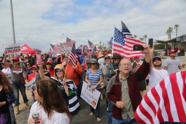 Başkan Donald Trump. Huntington Sahili, CA - 25 Mart 2017: Amerika 'yı Tekrar Harika Yap Yürüyüşü. Cumhuriyetçi başkan Donald Trump 'ın destekçileri ve protestocuları Huntington Beach' teki MAGA yürüyüşünde tezahürat ve alay ediyorlar. Başkan Trump Destekçileri. 
