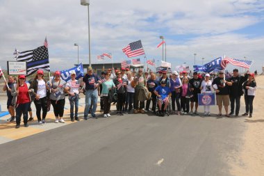 Huntington Sahili, CA - 25 Mart 2017: Amerika 'yı Tekrar Harika Yap Yürüyüşü. Cumhuriyetçi başkan Donald Trump 'ın binlerce destekçisi Huntington Sahili' ndeki bir MAGA yürüyüşünde bayrak salladı. Birkaç Anti-Trump protestocusu ruhlarını göstermek için geldi.. 