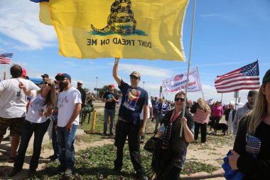 Huntington Sahili, CA - 25 Mart 2017: Amerika 'yı Tekrar Harika Yap Yürüyüşü. Cumhuriyetçi başkan Donald Trump 'ın binlerce destekçisi Huntington Sahili' ndeki bir MAGA yürüyüşünde bayrak salladı. Birkaç Anti-Trump protestocusu ruhlarını göstermek için geldi.. 