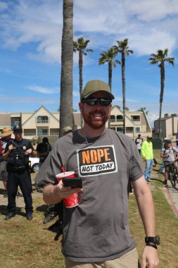 Huntington Sahili, CA - 25 Mart 2017: Amerika 'yı Tekrar Harika Yap Yürüyüşü. Cumhuriyetçi başkan Donald Trump 'ın binlerce destekçisi Huntington Sahili' ndeki bir MAGA yürüyüşünde bayrak salladı. Birkaç Anti-Trump protestocusu ruhlarını göstermek için geldi.. 