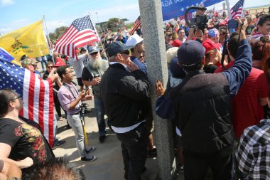 Huntington Sahili, CA - 25 Mart 2017: Amerika 'yı Tekrar Harika Yap Yürüyüşü. Cumhuriyetçi başkan Donald Trump 'ın binlerce destekçisi Huntington Sahili' ndeki bir MAGA yürüyüşünde bayrak salladı. Birkaç Anti-Trump protestocusu ruhlarını göstermek için geldi.. 