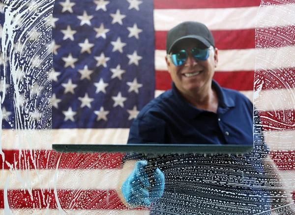 Window Cleaning. Window Washing. American Window Washing. American Window Washing. Professional Window Cleaner. Window Cleaning. Window Washing. American flag background.  A window washer cleans windows with his squeegee and soapy water. Clean Glass.