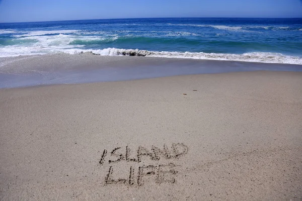 Words in Sand. Words written in sand on the beach.  ISLAND LIFE written in the sand of Laguna Beach California with the pacific ocean background. ISLAND LIFE written in sand on the beach. Work from home. work from the beach. work on vacation. no work