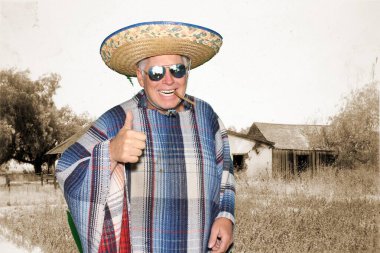 A man wears a Mexican Sombrero and a Serape or Poncho, sunglasses and smokes a big cigar as he celebrate a Mexican holiday. Isolated on white, Room for text. Clipping Path. Photo Booth. A man dresses up while in a Photo Booth at a party.  clipart