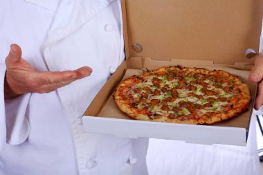 Pizza şefi. - Pizza. Pizza turtası. Gurme Pizza Şefi. Beyazda izole edilmiş. Mesaj için yer var. Beyaz şef kıyafeti ve beyaz şef şapkası içinde bir pizza şefi taze pişmiş pizza tutar. Şef restoranda pizza pişiriyor. Aşçı şefi. Şef. Fırıncı. Şef pizzasıyla. 