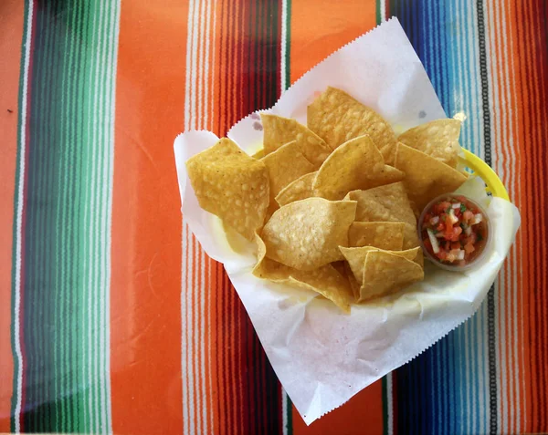 Mexican Food. Mexican Soup. Traditional Mexican food Mexican soup with meat balls and vegetables. Mexican albondigas soup in a white ceramic bowl and plate on a traditional Mexican serape blanked table cloth and a spoon. Chips. Chips and Salsa. Food.