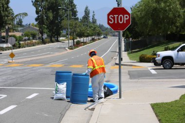 Tehlikeli madde. Lake Forest, California, 23 Mayıs 2017: Tehlikeli madde ekibi, yüzme havuzu kimyasalları içeren tek bir kamyon kazasını temizler ve zehirli sıvıların çevreye salınmasını önler. Tehlikeli madde kıyafetleri içinde itfaiye ve acil durum ekipleri. 