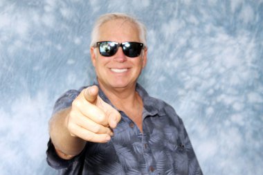 Fotoğraf kabini. Bir adam bir partide fotoğraf kabininde resmi için poz verirken gülümser ve güler. Fotoğraf Booth Party seti. Gözlükler, şapkalar, dudaklar, bıyıklar, fotoğraf kabini partisi için maskeler. Düğün Partisi komik resimleri. 