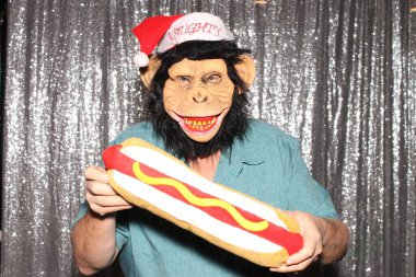 Noel zamanı. Fotoğraf kabini. Bir adam fotoğraf kabininde poz veriyor. Maymun Adam komiktir. Komik Maymun Adam Booth Fotoğrafları. Bir adam partide fotoğraf kabininde Noel şapkasıyla birlikte Maymun Maskesi takıyor. Şempanze fotoğraf kabininde komik aksesuarlar tutuyor..