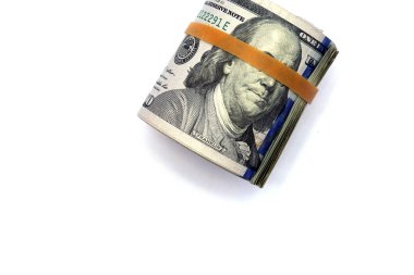 us money rolled up with a rubber band isolated on white. the most popular money.