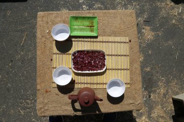 pork buns and steamed clams with green tea on a bamboo mat with chop sticks outdoors on burlap.