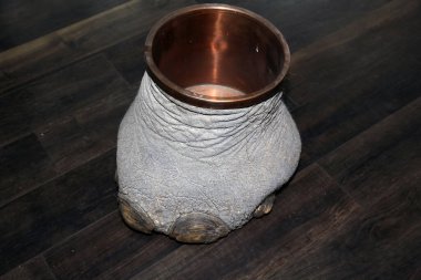 Las Vegas, Nevada 3-15-2018: An antique Elephants Foot Brass Lined Trash Can for sale in an antique shop on a wooden floor.
