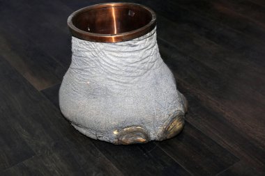 Las Vegas, Nevada 3-15-2018: An antique Elephants Foot Brass Lined Trash Can for sale in an antique shop on a wooden floor.