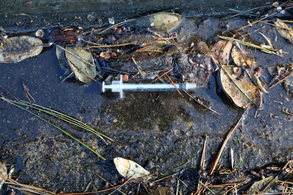 歩道や主要都市や町の汚れた溝に捨てられた低気圧針 薬物乱用は多くの州で制御不能で ヘロインは選択の主な薬です — ストック写真