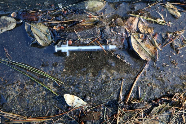 歩道や主要都市や町の汚れた溝に捨てられた低気圧針 薬物乱用は多くの州で制御不能で ヘロインは選択の主な薬です — ストック写真