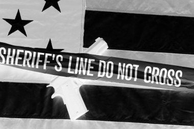 45 pistol with an American Flag, and Sheriff's Line Do Not Cross and Crime Scene Tape. Represents the Second Amendment, the right to own guns, and the current anti gun politics. march for life