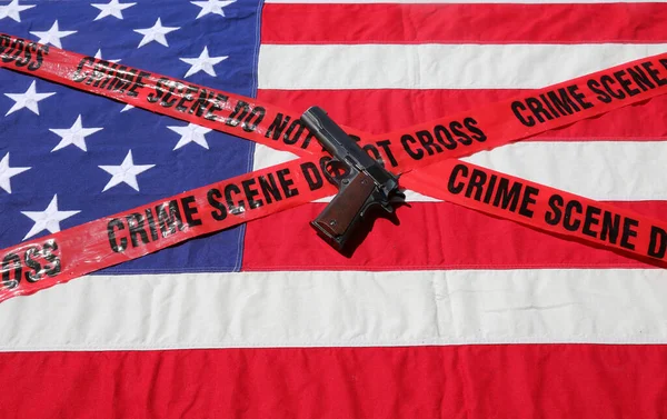 45 pistol with an American Flag, and Sheriff\'s Line Do Not Cross and Crime Scene Tape. Represents the Second Amendment, the right to own guns, and the current anti gun politics. march for life