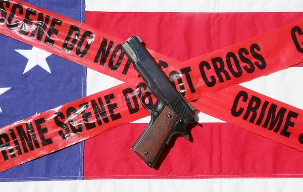 45 pistol with an American Flag, and Sheriff's Line Do Not Cross and Crime Scene Tape. Represents the Second Amendment, the right to own guns, and the current anti gun politics. march for life