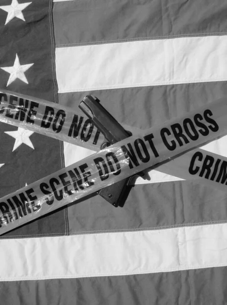 45 pistol with an American Flag, and Sheriff\'s Line Do Not Cross and Crime Scene Tape. Represents the Second Amendment, the right to own guns, and the current anti gun politics. march for life