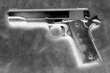 45 caliber semi automatic pistol on a leather background. Inverted image for an artistic effect.