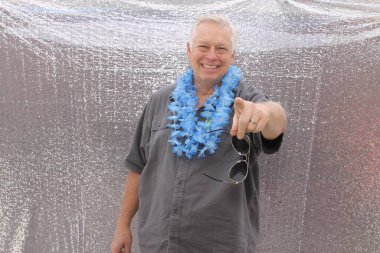 Fotoğraf kabininde mutlu bir orta yaşlı adam. Mutlu bir adam güler, şarkı söyler ve bir partide fotoğraf kabininde gülümserken komik suratlar yapar. Parti Zamanı Fotoğraf Odası.