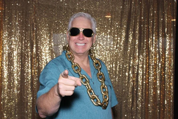 A happy middle aged man in a Photo Booth. A happy man laughs, sings, and makes funny faces as he smiles while in a Photo booth at a Party. Party Time Photo Booth.