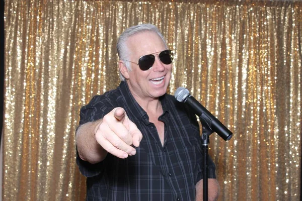 A happy middle aged man in a Photo Booth. A happy man laughs, sings, and makes funny faces as he smiles while in a Photo booth at a Party. Party Time Photo Booth.