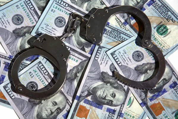 Money with Handcuffs. American Money Locked up with Hand Cuffs. Isolated on white. Room for text. Financial and Banking Concepts. Money or savings locked up for the future concepts.