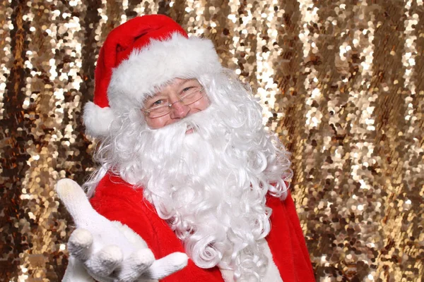 Santa Claus. Santa Claus holds out his hand as to ask You the Viewer, What have you done for your FELLOW MAN or Woman this Christmas Holiday Season? Gold Sequin Background. Christmas Holiday Images.