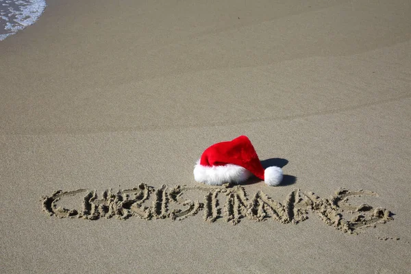 Santa Hat Santa Claus Hat Beach Word Christmas Written Sand — Zdjęcie stockowe