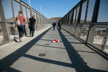 San Ysidro, California - 11/26/2018: Pedestrian bridge to and from Mexico. A Santa Claus hat lays on the sidewalk as people walk by on their way to or from Mexico from the California USA side.