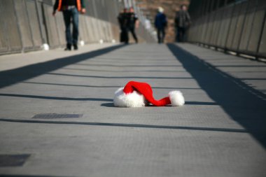 San Ysidro, California - 11/26/2018: Pedestrian bridge to and from Mexico. A Santa Claus hat lays on the sidewalk as people walk by on their way to or from Mexico from the California USA side.