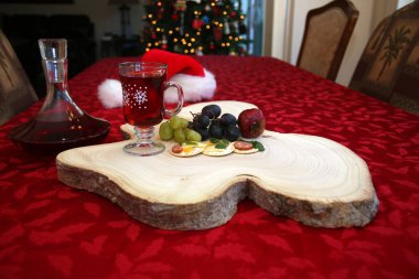 Noel zamanı. Noel için kesme tahtasında aperatifler. Peynir, meyve, sosis, kraker ve taze otlardan oluşan aperatifler. Tahta Ağaç Kesme Tahtası. Noel atıştırmalıkları. Et, peynir ve meyveli bisküvi. Tahta kesme tahtası. Atıştırmalıklar.