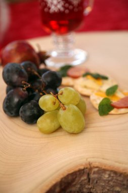 Noel zamanı. Noel için kesme tahtasında aperatifler. Peynir, meyve, sosis, kraker ve taze otlardan oluşan aperatifler. Tahta Ağaç Kesme Tahtası. Noel atıştırmalıkları. Et, peynir ve meyveli bisküvi. Tahta kesme tahtası. Atıştırmalıklar.