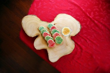 TOP DOWN VIEW. Christmas Cookies with Eggnog. Christmas Tree out of focus in the background with cookies and Eggnog for Santa. Cookies on a Tree Stump Cutting Board.
