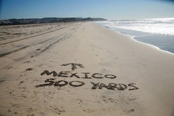沙子里的字 墨西哥500码 箭头指向墨西哥 写在墨西哥和美利坚合众国边界的沙滩上 方向标志 — 图库照片