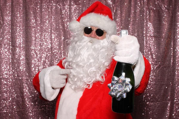 Święty Mikołaj Okularach Przeciwsłonecznych Trzymając Butelkę Szampana Błyszczącym Różowym Cekinowym — Zdjęcie stockowe