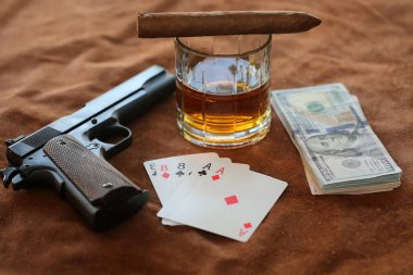 Puro. Küba purosu, Whiskey, Cash, Poker Hand ve deri arka planda bir el tabancası. Silahlı bir poker oyuncusu, rakipleriyle kapışır. Kumarhanede silahlı bir poker oyuncusu. Ölü adamın elinde as ve sekizli tabanca, viski ve puro var..  