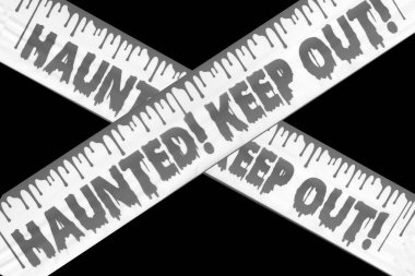 HAUNTED! KEEP OUT! Haunted. Keep Out Caution Tape. Halloween Decorations. Stay Out. Warning. Danger Keep Out Crime Strip Scene Halloween Night In Haunted House. Scary sign outside. Halloween. Keep Out
